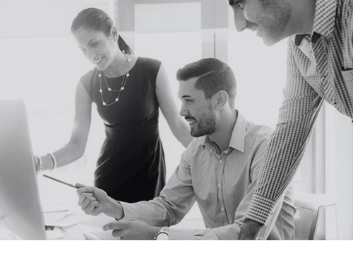 Three business people looking at a computer monitor